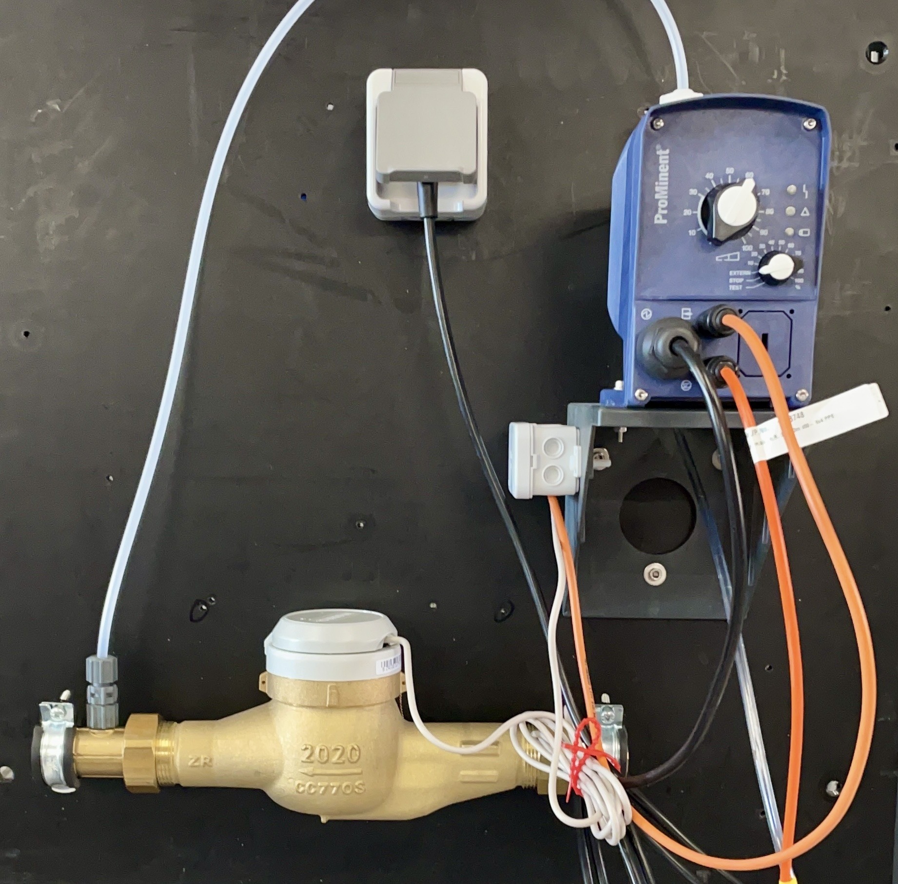Pumpe2 Dosierpumpe und Wasserzähler auf schwarzer Montageplatte